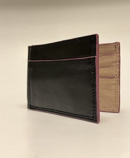 Outside of wallet is black with purple edges and tan inside.